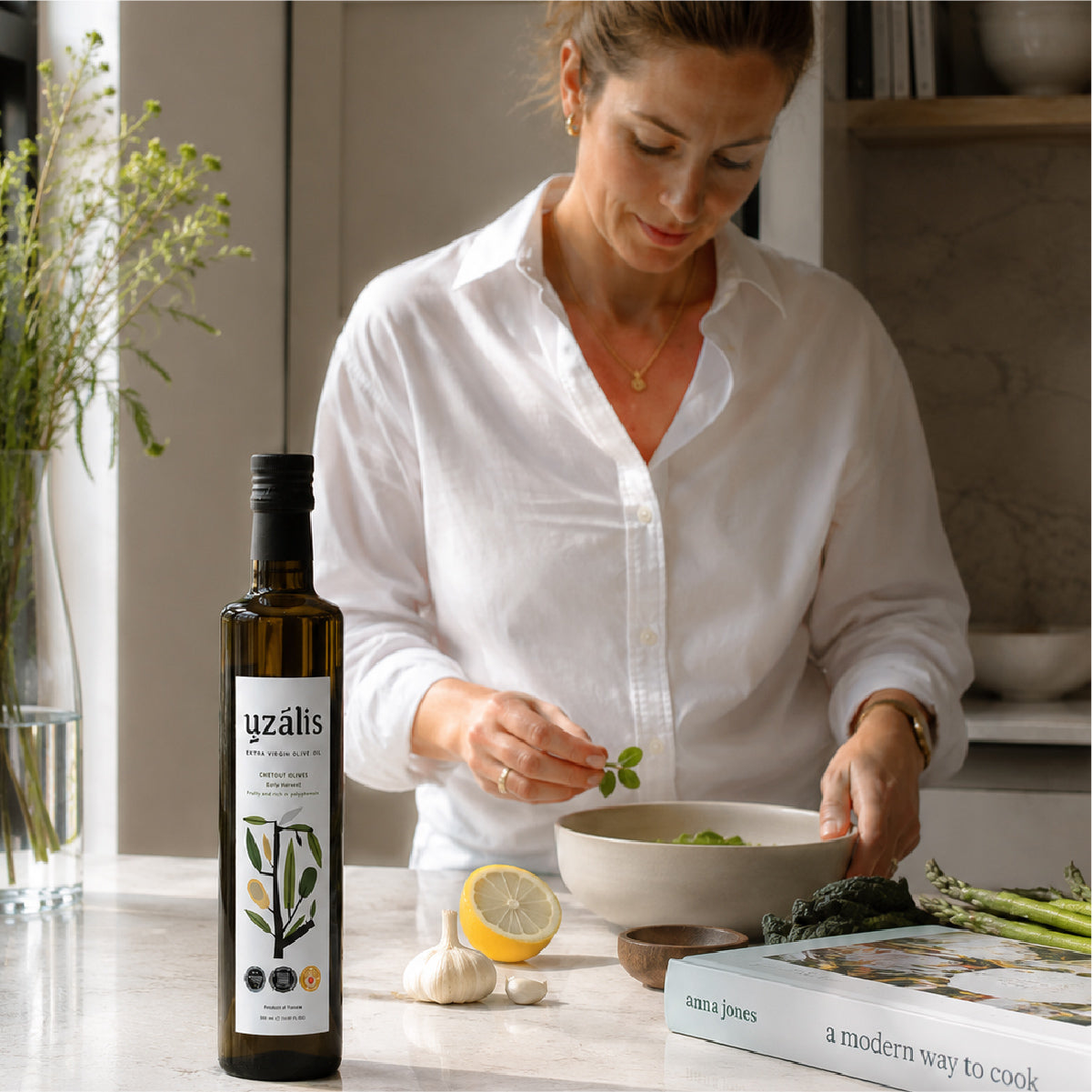 Woman finishing a modern salad with premium Tunisian extra virgin olive oil